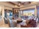 Cozy Gathering room with stone fireplace, beamed ceilings, and a view of the outdoor patio at 15956 E Tombstone Trl, Fountain Hills, AZ 85268