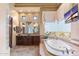 Main bathroom featuring a soaking tub, custom vanity, and natural light at 15956 E Tombstone Trl, Fountain Hills, AZ 85268