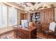 Home office featuring custom built-ins, a large wooden desk, and plantation shutters at 15956 E Tombstone Trl, Fountain Hills, AZ 85268