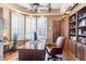 Bright office space featuring a large window with shutters, wood floors, and custom built-ins at 15956 E Tombstone Trl, Fountain Hills, AZ 85268