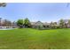 Large, well-maintained backyard with vibrant green grass, mature trees, and recreational amenities at 1632 S Alba Cir, Mesa, AZ 85204