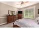 Bedroom with a TV, bed with patterned cover, and dresser set against a window at 1632 S Alba Cir, Mesa, AZ 85204