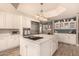 Spacious kitchen with white cabinets, stainless steel appliances, and a large center island with cooktop at 1632 S Alba Cir, Mesa, AZ 85204