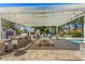 Outdoor kitchen and dining area featuring a grill, picnic table, and comfortable seating beneath a pergola at 1632 S Alba Cir, Mesa, AZ 85204