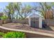 A well-maintained storage shed on a gravel lot with mature trees and a small privacy fence at 1632 S Alba Cir, Mesa, AZ 85204