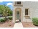 Inviting home entrance featuring an arched entryway, cheerful wreath, 'hello' doormat and desert landscaping at 1679 E Dogwood Ln, Gilbert, AZ 85295