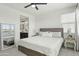 Bright main bedroom featuring a luxurious bed, a ceiling fan, and an ensuite bathroom with modern finishes at 1679 E Dogwood Ln, Gilbert, AZ 85295