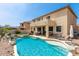 Gorgeous backyard features a sparkling pool with rock accents and a covered patio with comfortable seating and a grill at 17005 S Coleman St, Phoenix, AZ 85045