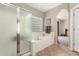 Bathroom featuring a glass shower, bathtub, tile floor, and a window at 17005 S Coleman St, Phoenix, AZ 85045
