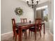A well-lit dining room with a wooden table and chairs under a chandelier at 17005 S Coleman St, Phoenix, AZ 85045