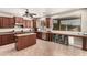 Open kitchen with dark cabinets, large window, breakfast bar with stools, and tile flooring at 17005 S Coleman St, Phoenix, AZ 85045