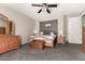 Spacious main bedroom featuring a ceiling fan, carpeted floor, and wood furniture at 17005 S Coleman St, Phoenix, AZ 85045