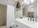 Bright bathroom with white vanity, modern fixtures, decorative shelving, and a shower with a white curtain at 1715 W Carol Ave, Mesa, AZ 85202