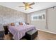 Inviting bedroom featuring a decorative brick wall, neutral tones, a ceiling fan, and stylish wood-look flooring at 1715 W Carol Ave, Mesa, AZ 85202
