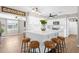 Bright kitchen featuring white cabinets, center island with seating, and modern appliances, complemented by wood-look flooring at 1715 W Carol Ave, Mesa, AZ 85202