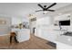 Open kitchen with white cabinets, stainless steel appliances, island seating, and wood-look floors, perfect for cooking and entertaining at 1715 W Carol Ave, Mesa, AZ 85202