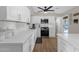 Well-lit kitchen showcases white countertops and cabinets, stainless steel appliances, and elegant wood-look flooring at 1715 W Carol Ave, Mesa, AZ 85202