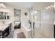 Bright bathroom featuring soaking tub, vanity, and enclosed glass shower with window views to bedroom at 17545 W Lilac St, Goodyear, AZ 85338