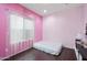 Bright pink bedroom with hardwood floors, a simple bed frame, and a large window with sheer curtains at 17545 W Lilac St, Goodyear, AZ 85338
