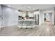 Open concept kitchen with island, white cabinets, stainless steel appliances, and pendant lighting at 17545 W Lilac St, Goodyear, AZ 85338