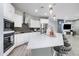Well-lit kitchen with stainless steel appliances, white cabinets, and a large center island with seating at 17545 W Lilac St, Goodyear, AZ 85338