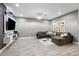 Spacious living room with gray walls, wood-look flooring, a large sectional sofa, and modern lighting at 17545 W Lilac St, Goodyear, AZ 85338