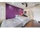Bright bedroom featuring purple accent wall, a ceiling fan, and ensuite bath access at 17545 W Lilac St, Goodyear, AZ 85338