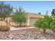 Southwestern-style home with neutral stucco and a two-car garage, with a unique rock garden landscape at 2167 E Aspen Dr, Tempe, AZ 85282