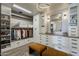 Organized walk-in closet with custom shelving, ample storage, and seating, designed for efficient wardrobe management at 2211 E Camelback Rd # 605, Phoenix, AZ 85016