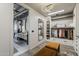 Modern walk-in closet leading to a stylish bathroom, with custom shelves and wood-look flooring at 2211 E Camelback Rd # 605, Phoenix, AZ 85016