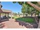 Expansive backyard with a covered patio, lush lawn, and mature trees, ideal for relaxation at 22521 N 60Th Ave, Glendale, AZ 85310