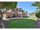 Beautiful home showcasing a spacious backyard with a pool, covered patio, and green lawn at 22521 N 60Th Ave, Glendale, AZ 85310