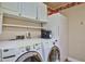 This laundry room includes a modern washer and dryer along with extra storage space for optimal organization at 22521 N 60Th Ave, Glendale, AZ 85310
