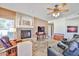 Comfortable living room with a cozy fireplace, ceiling fan, and plush seating for relaxation and entertaining guests at 22521 N 60Th Ave, Glendale, AZ 85310