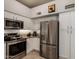 Modern kitchen featuring stainless steel appliances, white cabinets, and tiled backsplash at 2348 W Comstock Dr, Chandler, AZ 85224