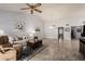 Spacious living room with neutral tones, tile flooring, ceiling fan, and large windows for natural light at 2348 W Comstock Dr, Chandler, AZ 85224