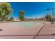 Well-maintained tennis court with new surface surrounded by a secure fence and lush landscaping, perfect for recreational play at 2348 W Comstock Dr, Chandler, AZ 85224