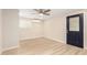 A cozy bedroom with new light-colored flooring, a ceiling fan and a door at 2356 W Catalina Ave, Mesa, AZ 85202