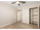 Bright bedroom features a ceiling fan, wood-look floors, and a closet with sliding doors at 2356 W Catalina Ave, Mesa, AZ 85202