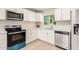 The kitchen features new white cabinets, stainless steel appliances, and a window at 2356 W Catalina Ave, Mesa, AZ 85202