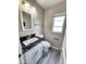 Bathroom with modern fixtures, striking black granite countertop, and wood-look vinyl flooring at 2945 N 19Th Ave # 78, Phoenix, AZ 85015