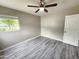 Bedroom showcasing the wood-look vinyl flooring, ceiling fan, and view of lush yard at 2945 N 19Th Ave # 78, Phoenix, AZ 85015