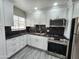 Modern kitchen featuring white cabinets, stainless steel appliances, and dark granite countertops at 2945 N 19Th Ave # 78, Phoenix, AZ 85015