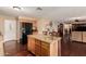 Kitchen island with granite countertops, barstool seating, modern appliances, and black refrigerator at 3135 W Molly Ln, Phoenix, AZ 85083