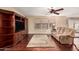 Comfortable living room with wood floors, ceiling fan, large sofa, and built-in media center for storage and entertainment at 3135 W Molly Ln, Phoenix, AZ 85083