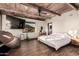 Comfortable main bedroom with wood ceiling beams, hard surface floors, a massage chair, and hillside views at 3201 N 91St St, Mesa, AZ 85207