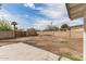 Spacious backyard features a block fence, a concrete patio, and mature trees under a partly cloudy sky at 3707 W Elm St, Phoenix, AZ 85019