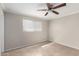 Neutral bedroom with a ceiling fan, tiled floors, and a window at 3707 W Elm St, Phoenix, AZ 85019