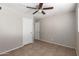 Neutral bedroom with a ceiling fan, tiled floors, and a closet door at 3707 W Elm St, Phoenix, AZ 85019