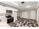 Bright, functional kitchen with stainless steel appliances, white cabinets and unique flooring at 3707 W Elm St, Phoenix, AZ 85019